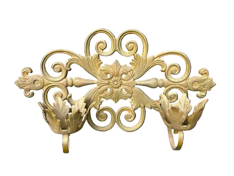 Decorative gold metal wall bracket on a gray background