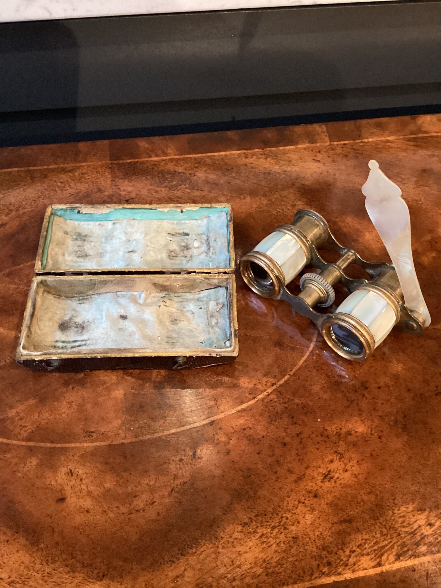 Vintage binoculars and a small box on a wooden surface