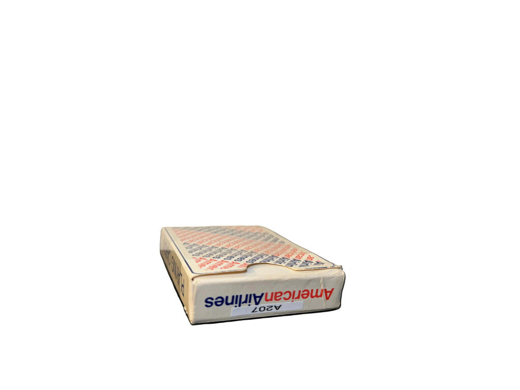 Box of American Airlines playing cards on a black surface with a white background