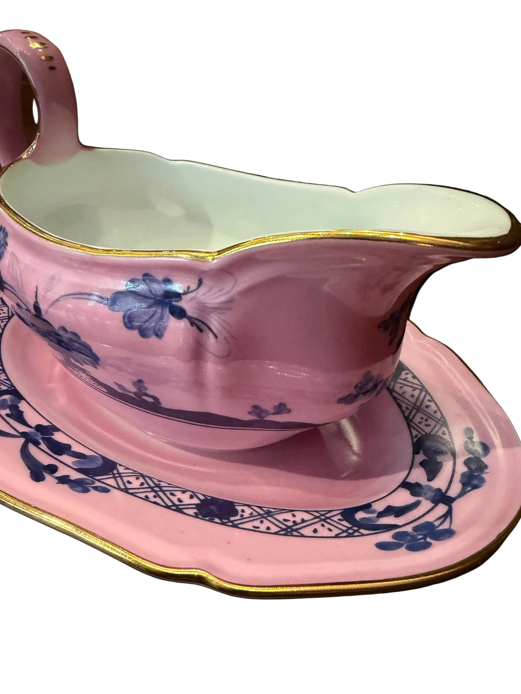 Pink ceramic item with blue floral patterns on a dark background