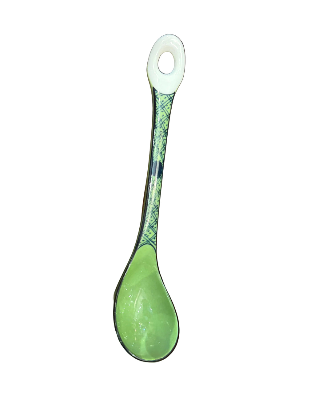 Green spoon with decorative handle on a wooden surface