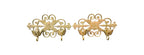 Two gold decorative wall hooks on a white background